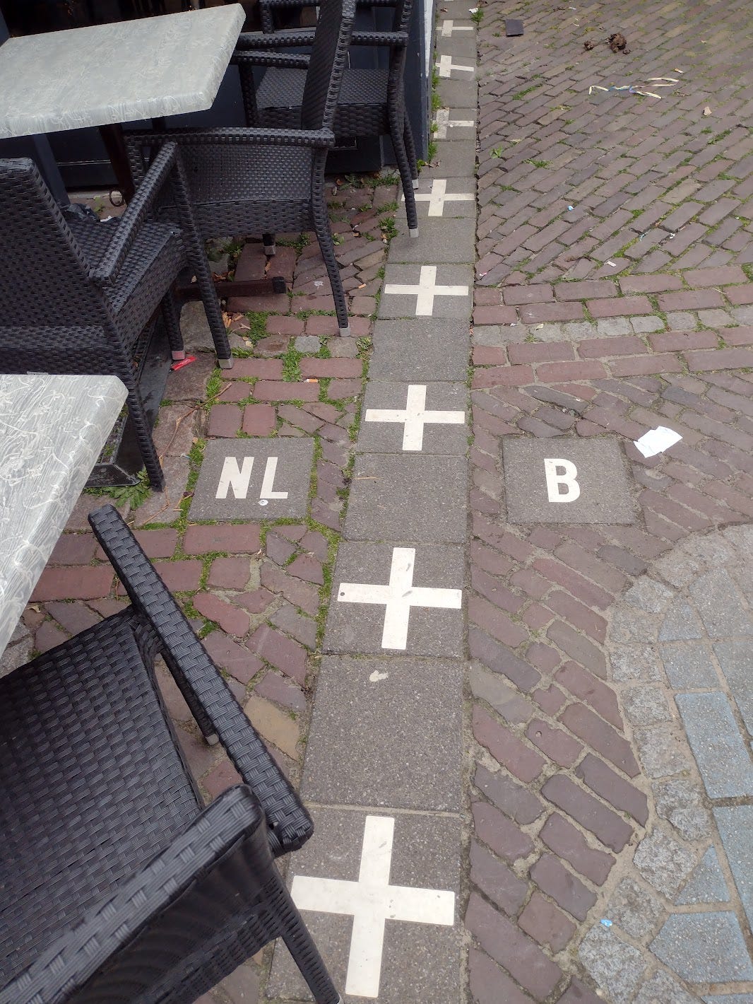 Outdoor dining with a border shown with tiles on the sidewalk