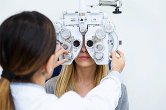 woman looking into mechanism at eye doctor